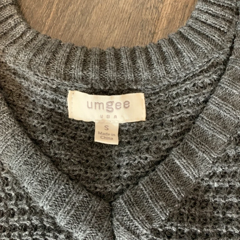 Umgee waffle knit cold‎ shoulder fringed sweater in charcoal.